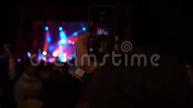 无法辨认的手剪影拍照或录制现场音乐音乐会与智能手机拍摄阶段的视频